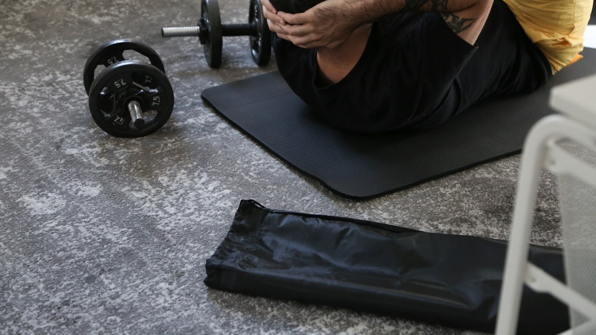a man is doing exercises on a mat with a barbell